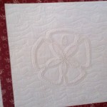 Custom quilting on the sand dollar block of a candlewick quilt