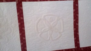 Custom quilting on the sand dollar block of a candlewick quilt