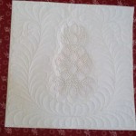 Custom quilting around pineapple candlewick block