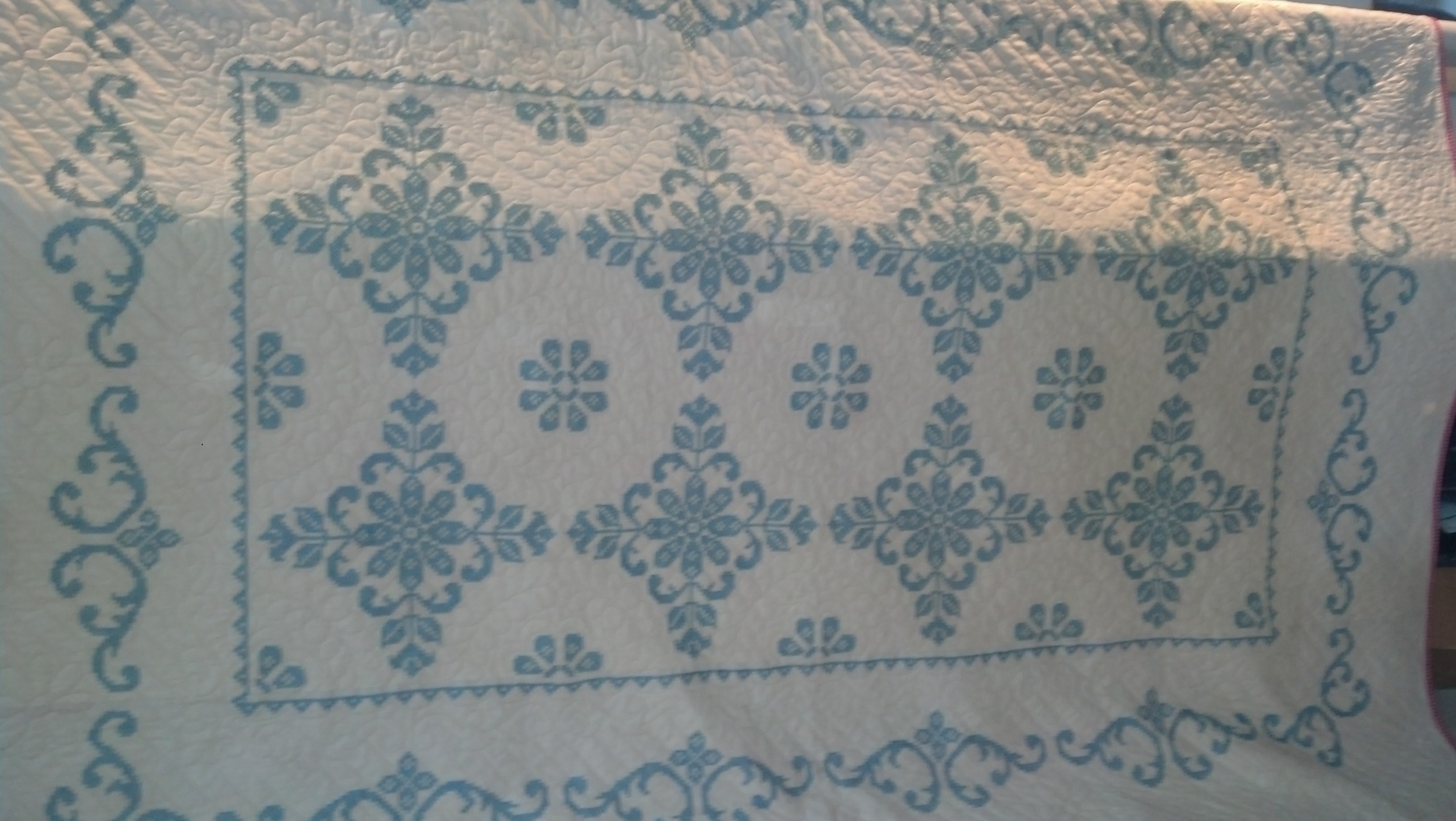 Custom quilting on cross stitch quilt